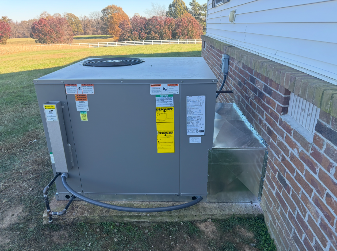 New rooftop-style packaged HVAC unit installed by J & L Heating & Cooling LLC at a West Tennessee home, with custom sheet-metal ductwork tied into the brick exterior